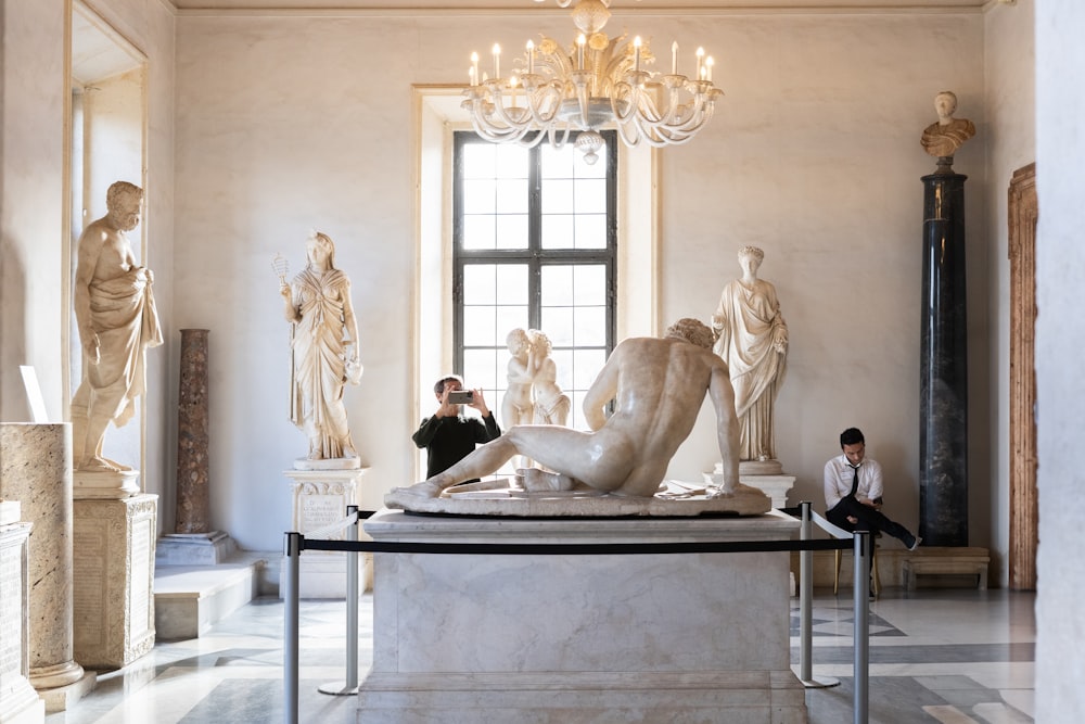 a man taking a picture of a sculpture in a museum