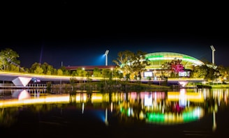 A night view of the stadium illuminated with colorful lights.