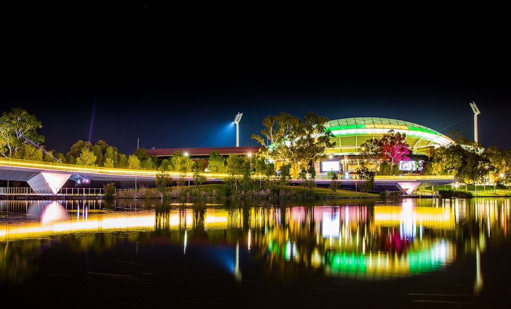 a night scene of a building and a bridge over a body of water