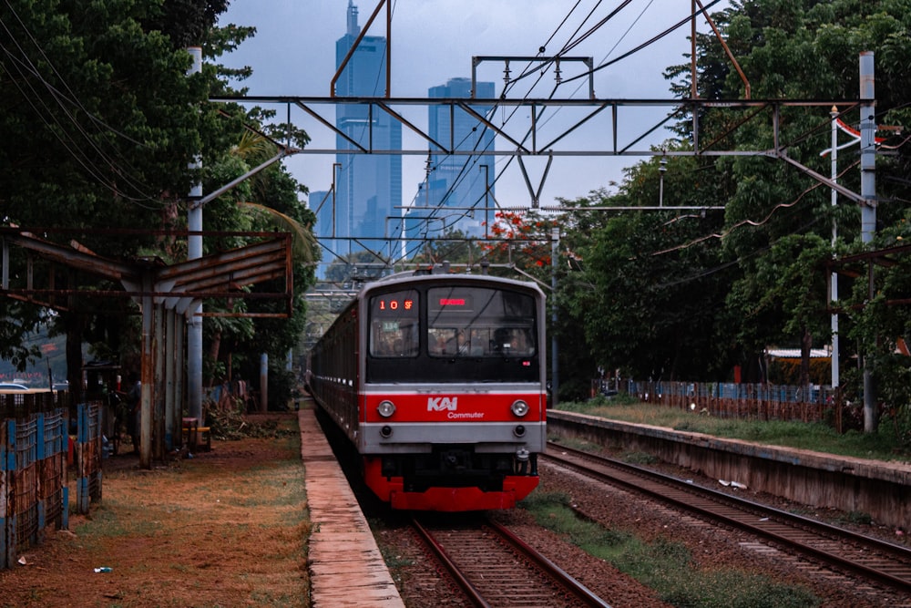 um trem vermelho e branco viajando pelos trilhos do trem