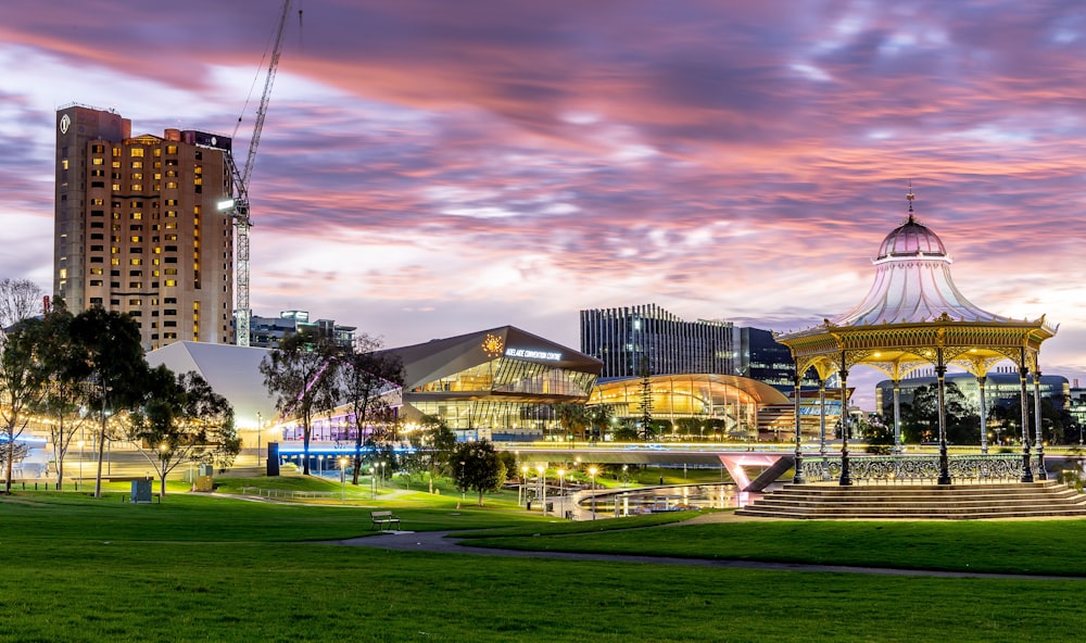 a park with a carousel and buildings in the background