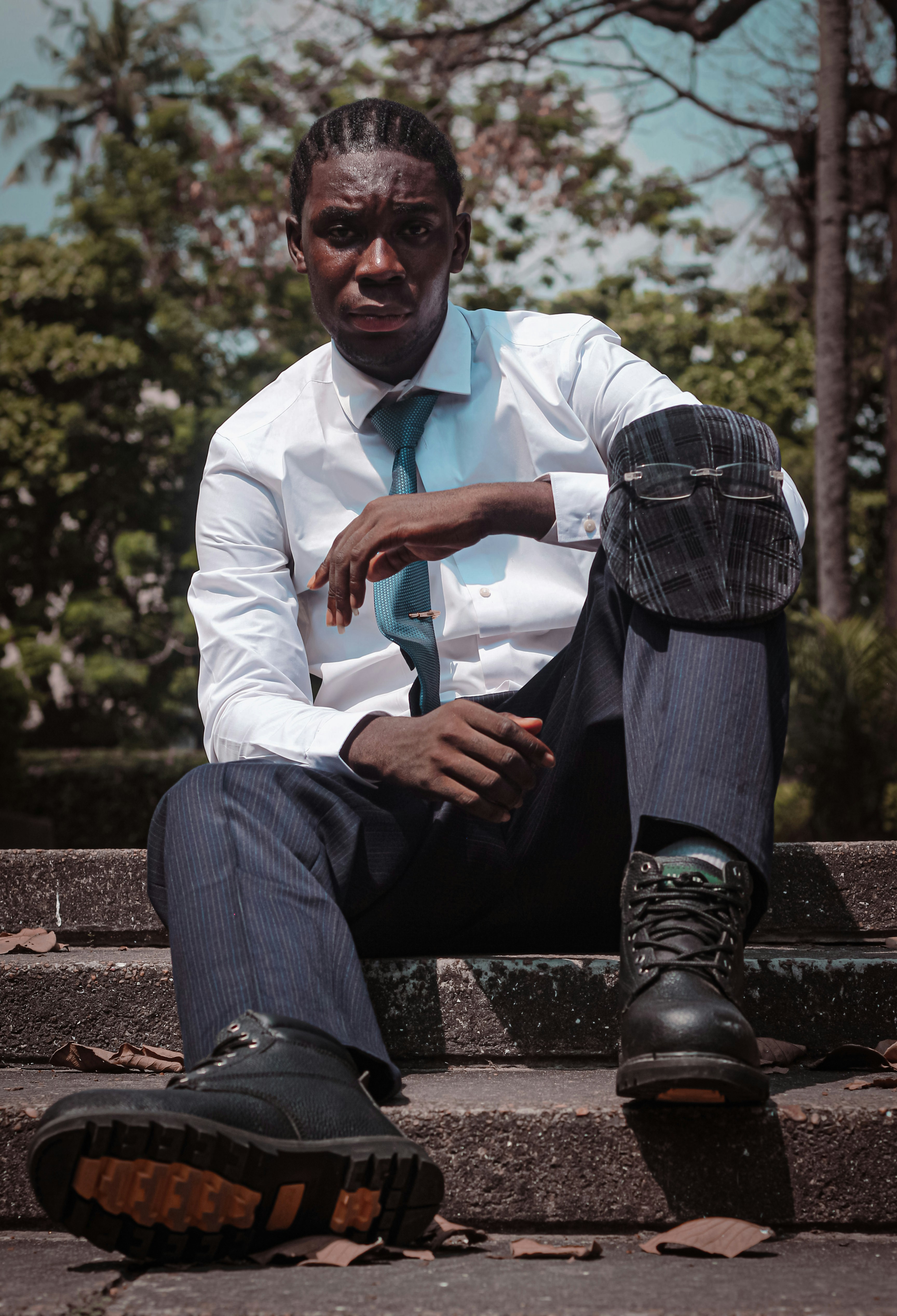 a man sitting on steps with a tie on