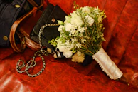 An elegant clutch bag placed beside a bouquet of fresh flowers on a marble table.
