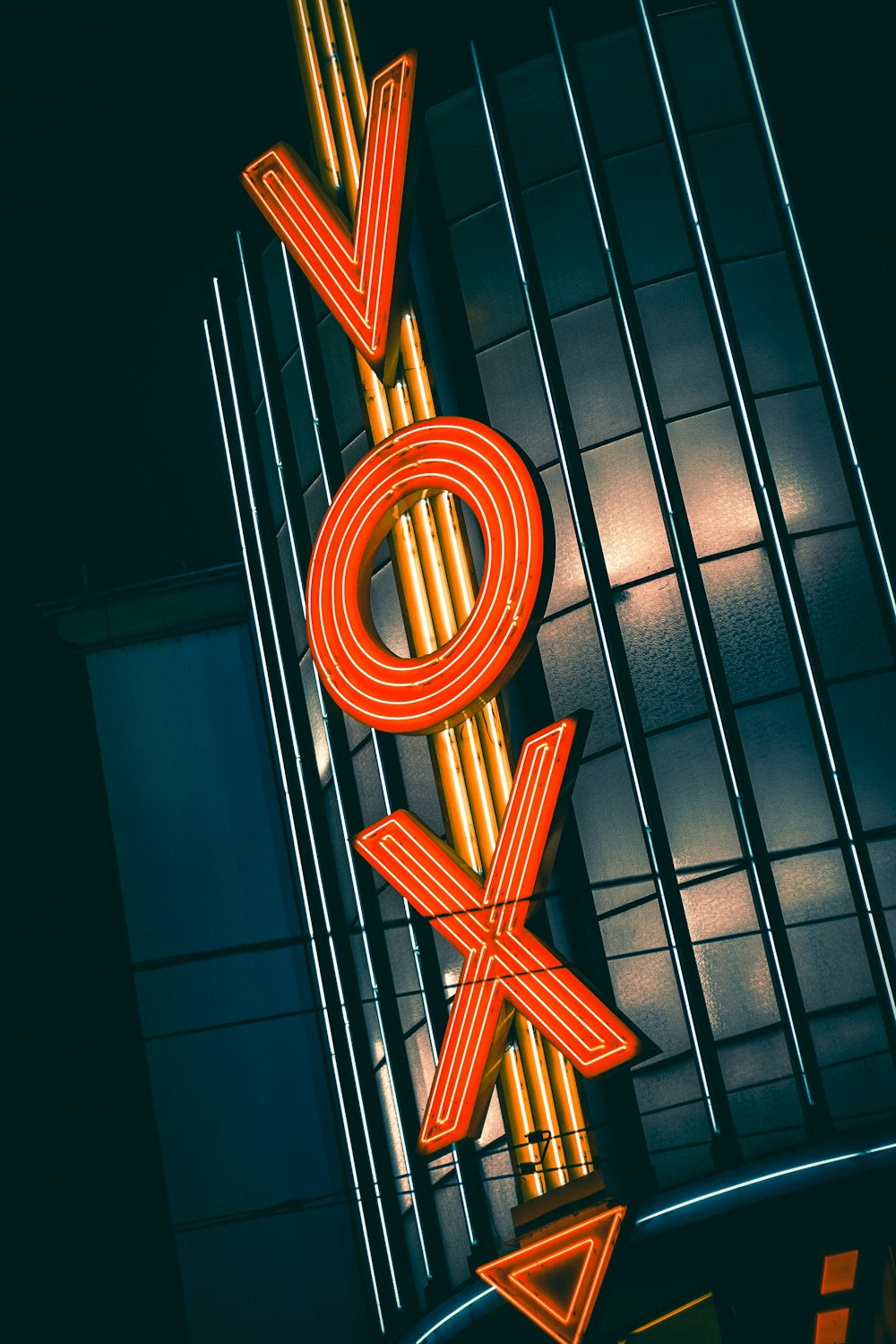 a neon sign that says roxy on the side of a building
