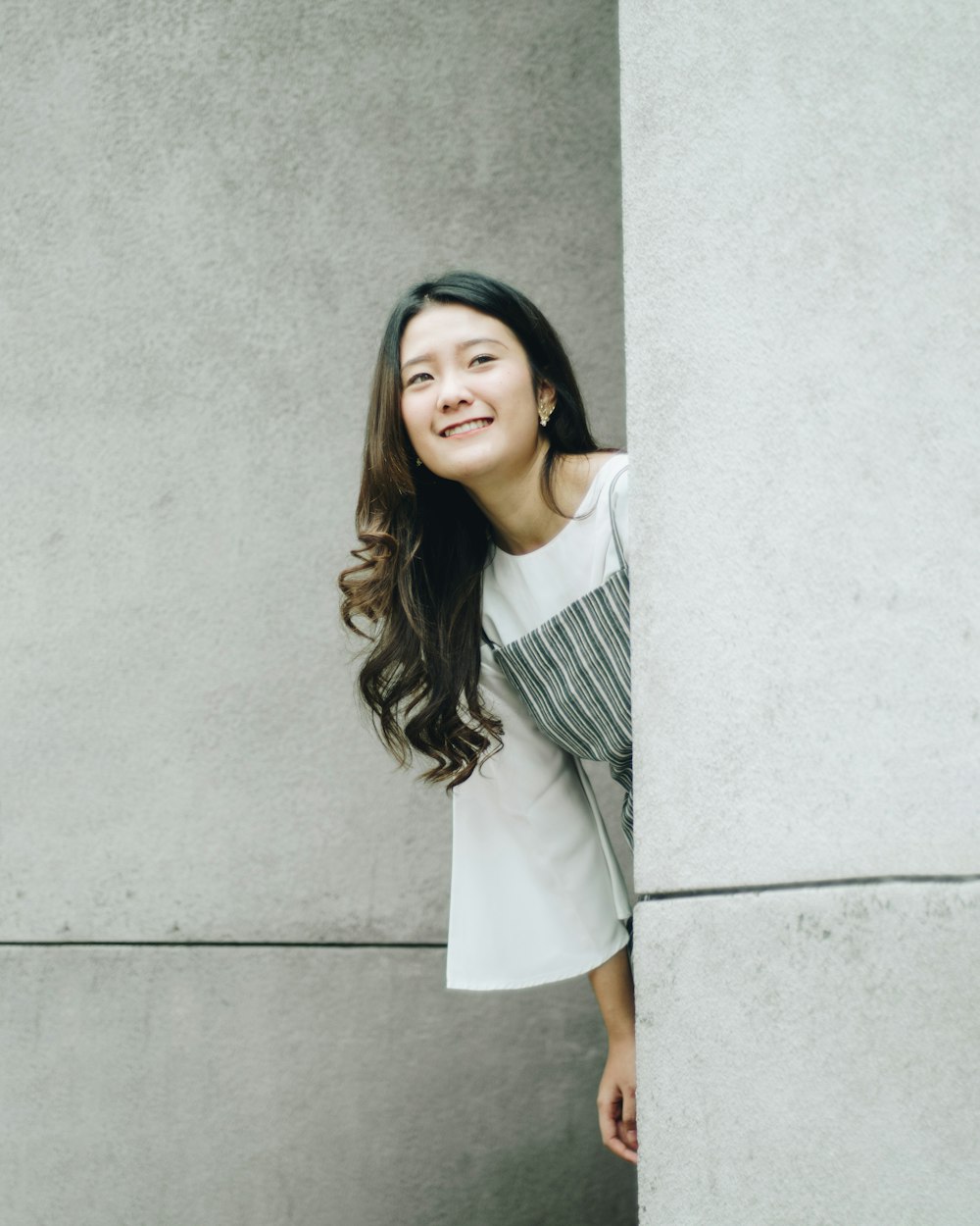a woman leaning against a wall and smiling