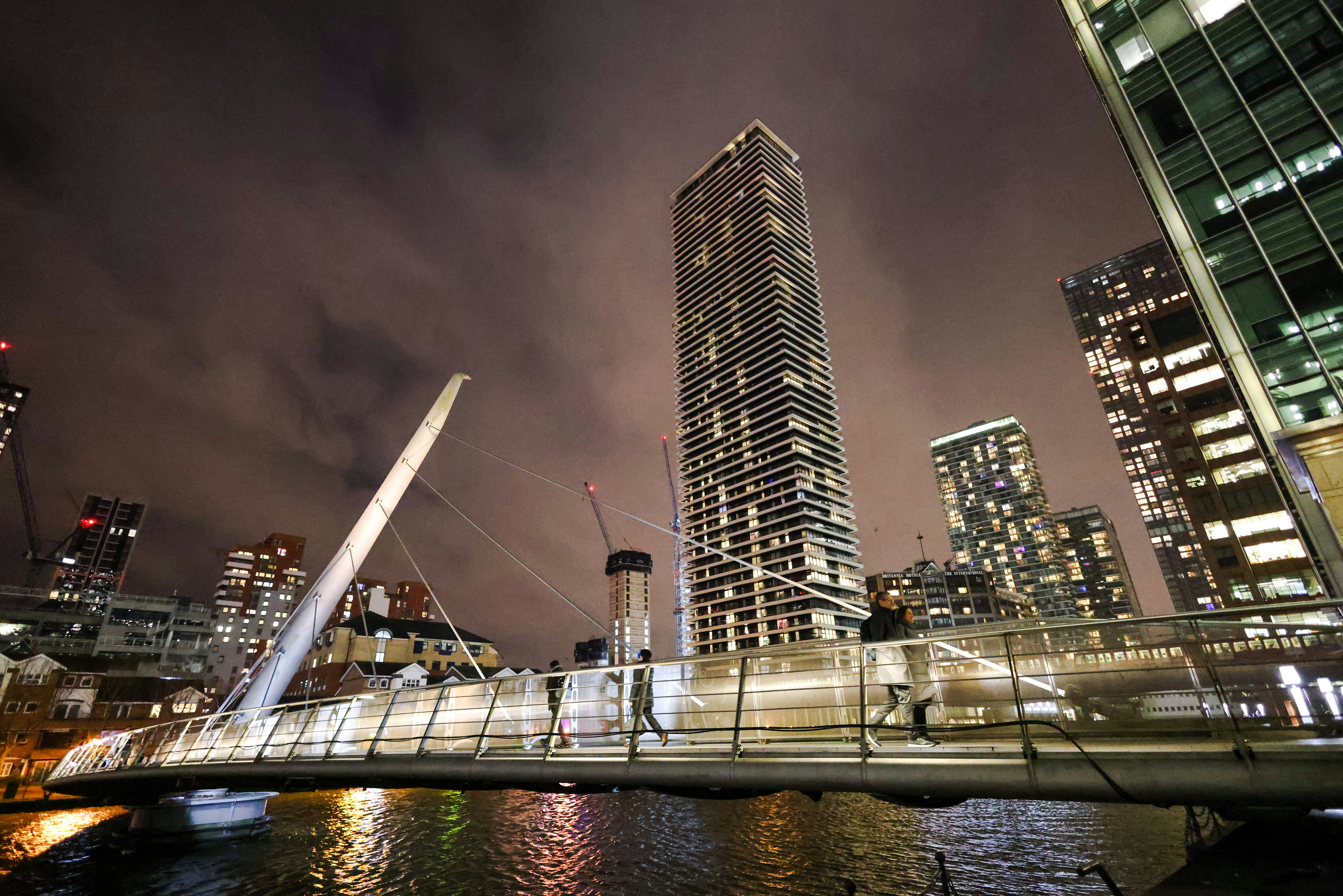 a bridge over a body of water in front of tall buildings