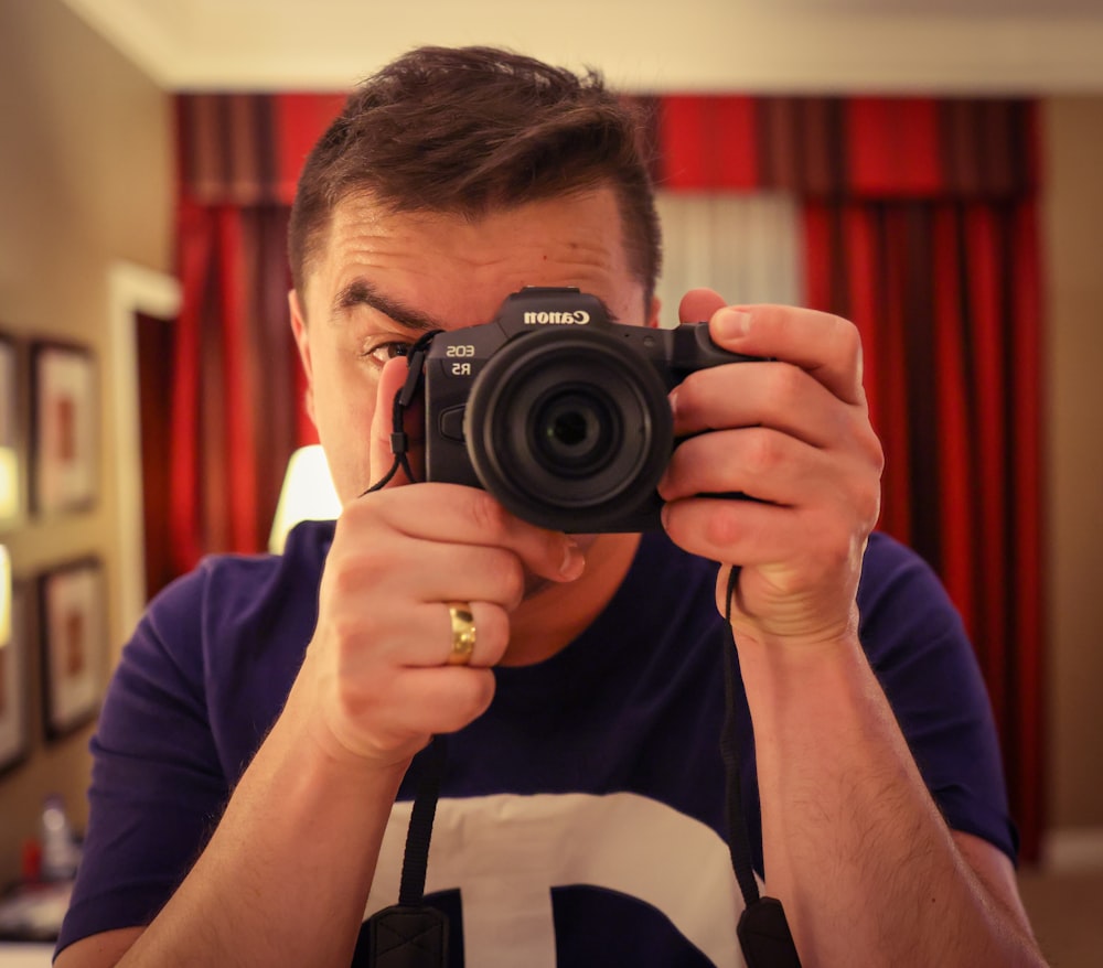 Un hombre tomándose una foto con una cámara