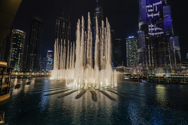 Night view of Dubai Fountain show with illuminated water jets.