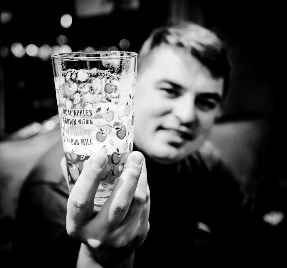 a person holding a glass with a message on it