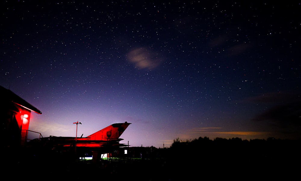 a night sky with stars and a red light