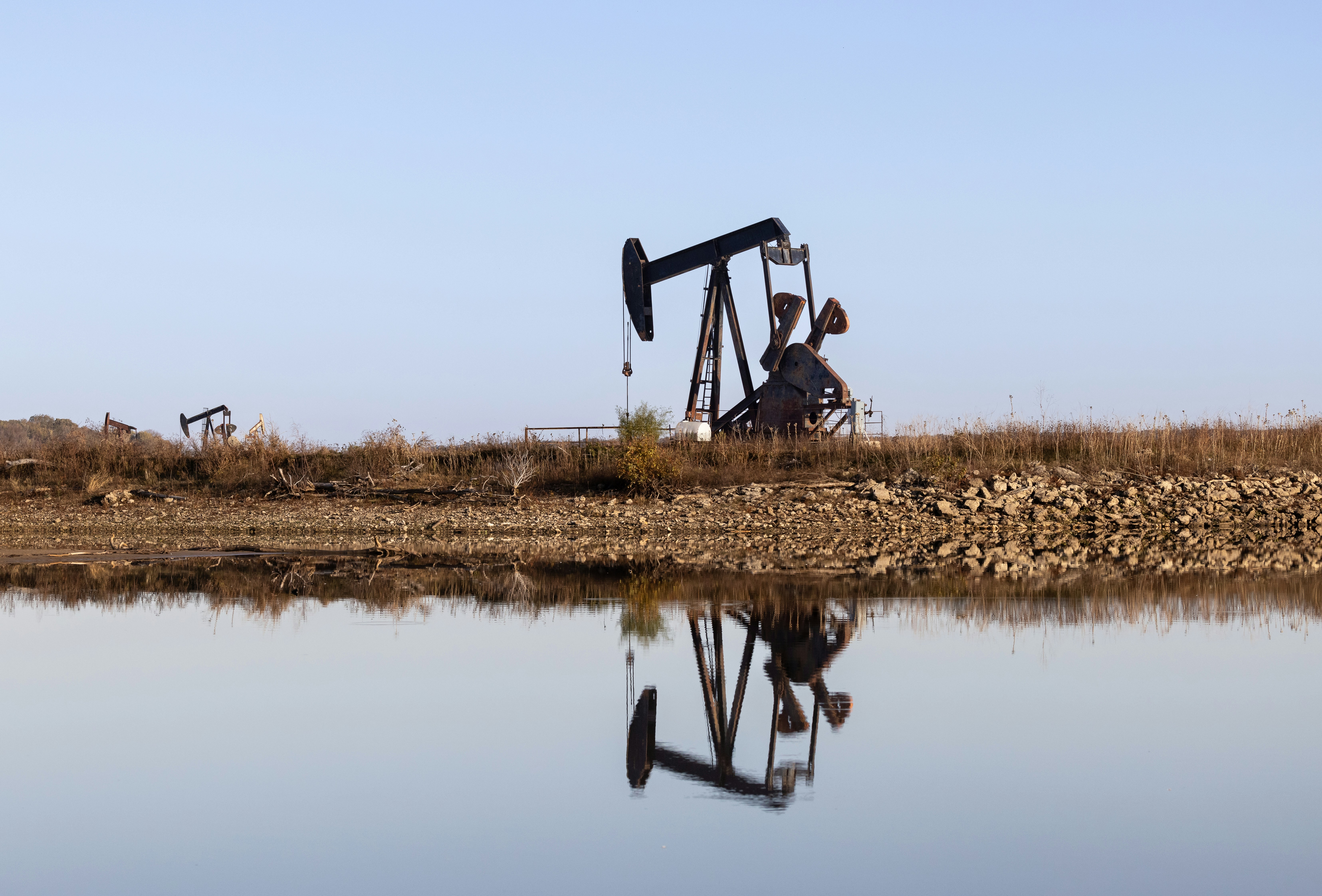 An oil pump sitting next to a body of water