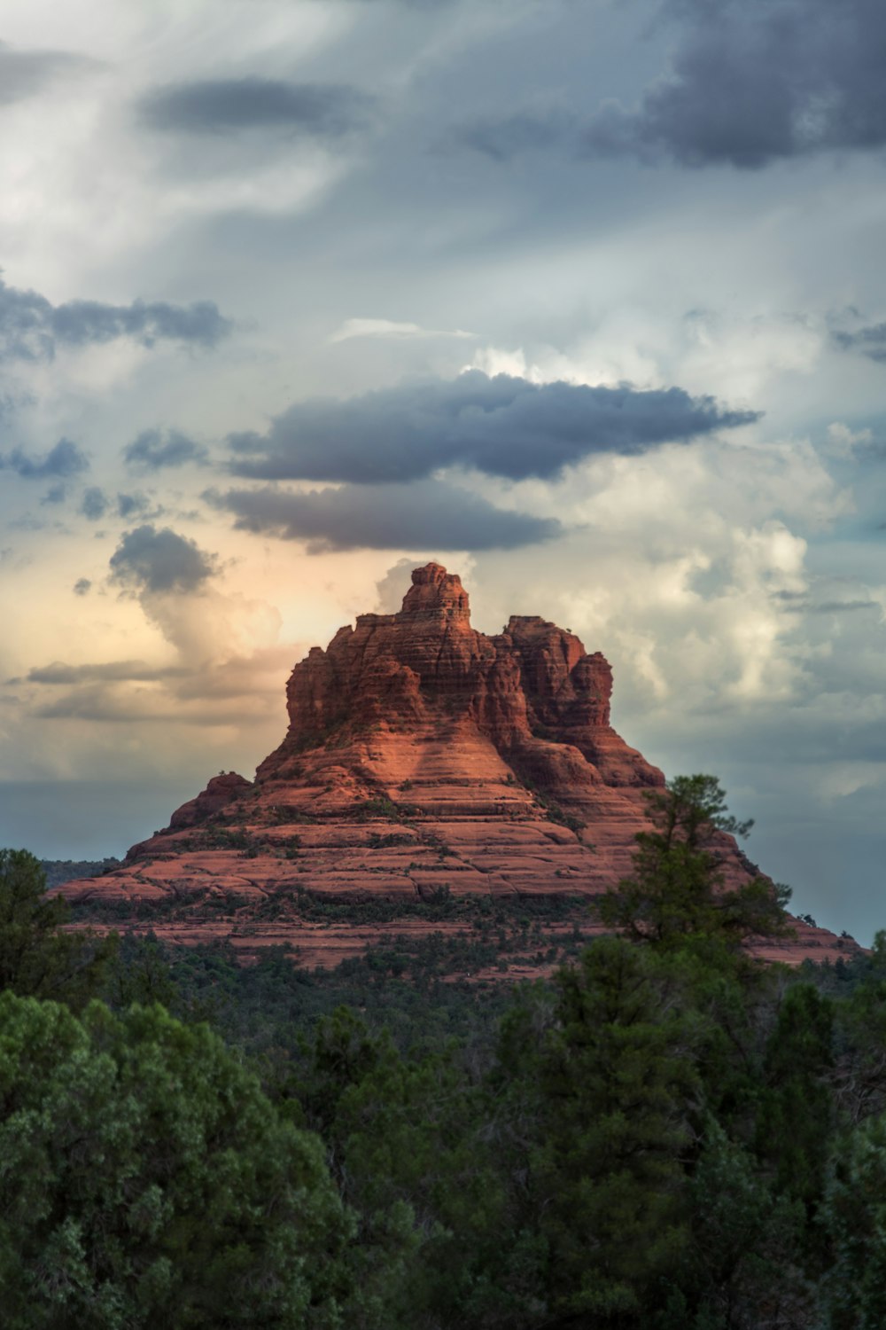 a large mountain with trees in front of it