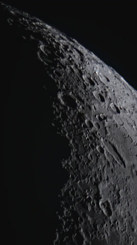 A close-up of the moon’s cratered surface illuminated by sunlight.