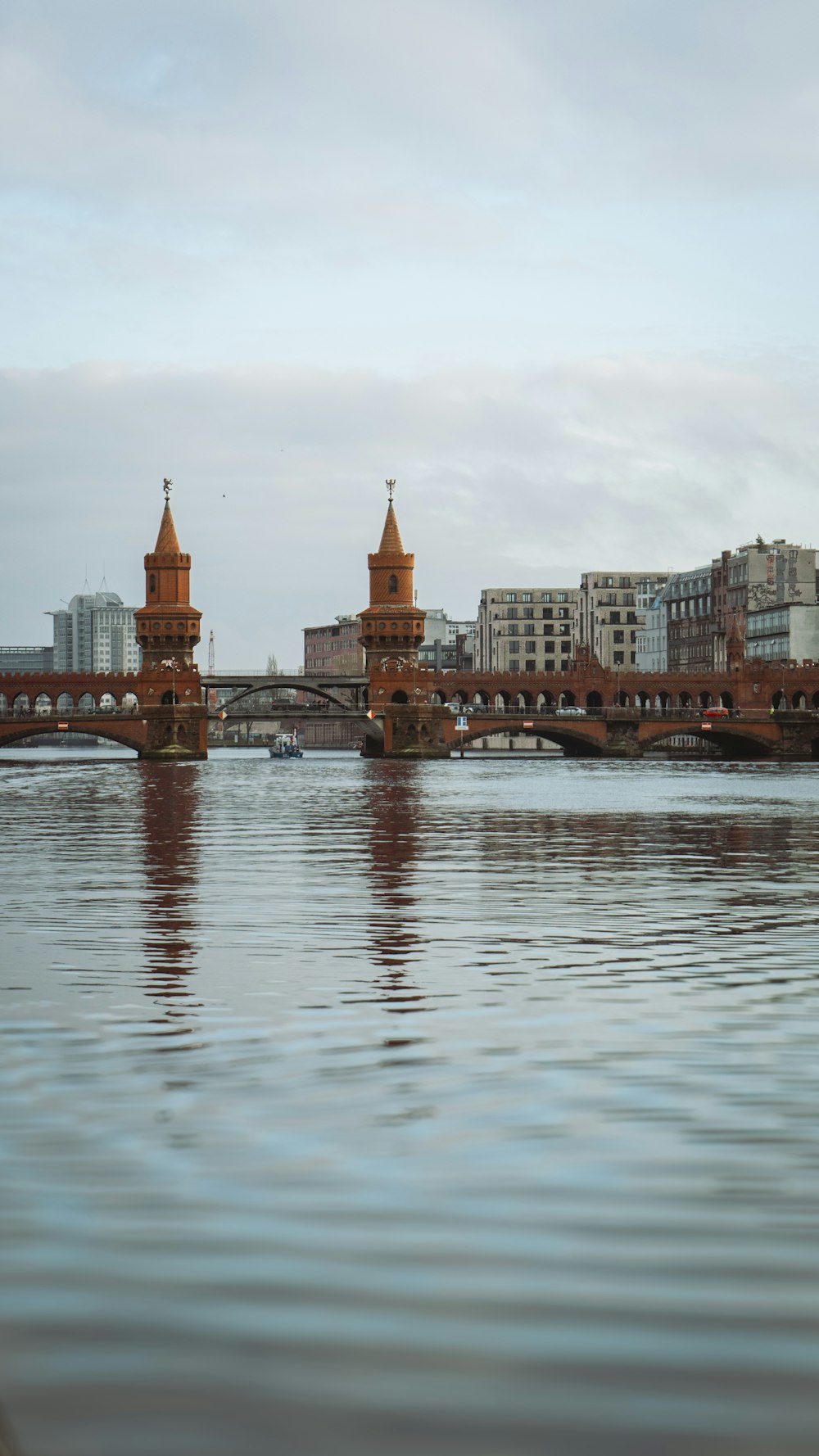 a large body of water with a bridge in the background