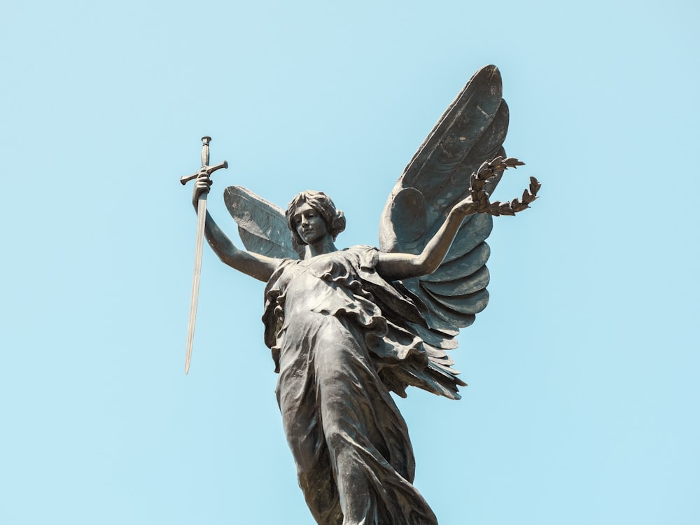 uma estátua de um anjo segurando uma espada