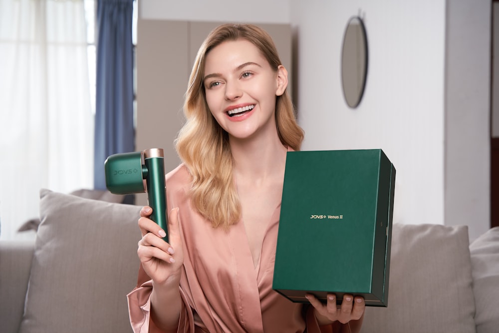 a woman holding a hair dryer and a box