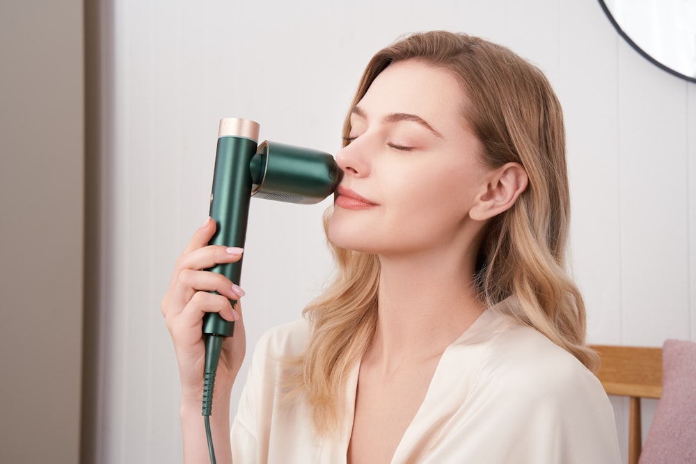 a woman blow drying her hair with a hair dryer