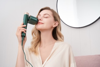 a woman blow drying her hair with a hair dryer