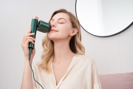 a woman blow drying her hair with a hair dryer