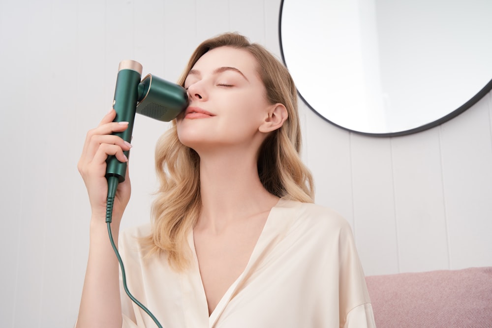 a woman blow drying her hair with a hair dryer