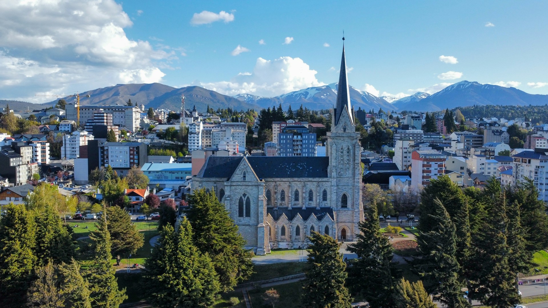 a church in the middle of a city with mountains in the background