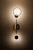Contemporary wall sconces casting gentle light on textured wallpaper.