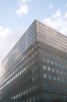 A sleek office building with large glass windows reflecting the sky.