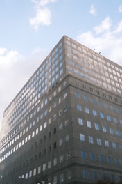 A sleek office building with large glass windows reflecting the skyline.