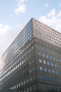 Spacious office building with glass windows reflecting the sky.