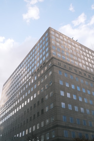 A modern office building reflecting sunlight, symbolizing smart and sustainable commercial spaces.