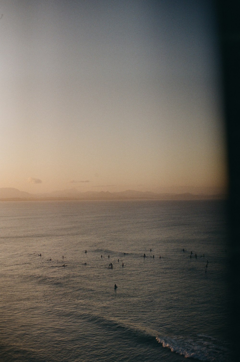 a group of people in the ocean at sunset