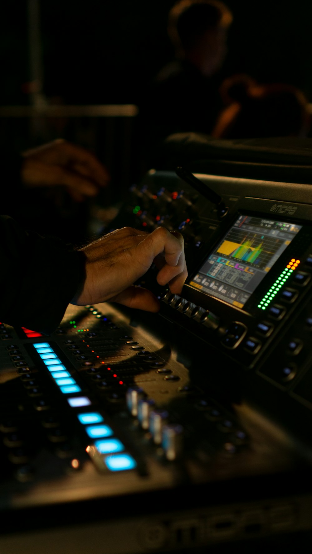 a person operating a sound board in a dark room