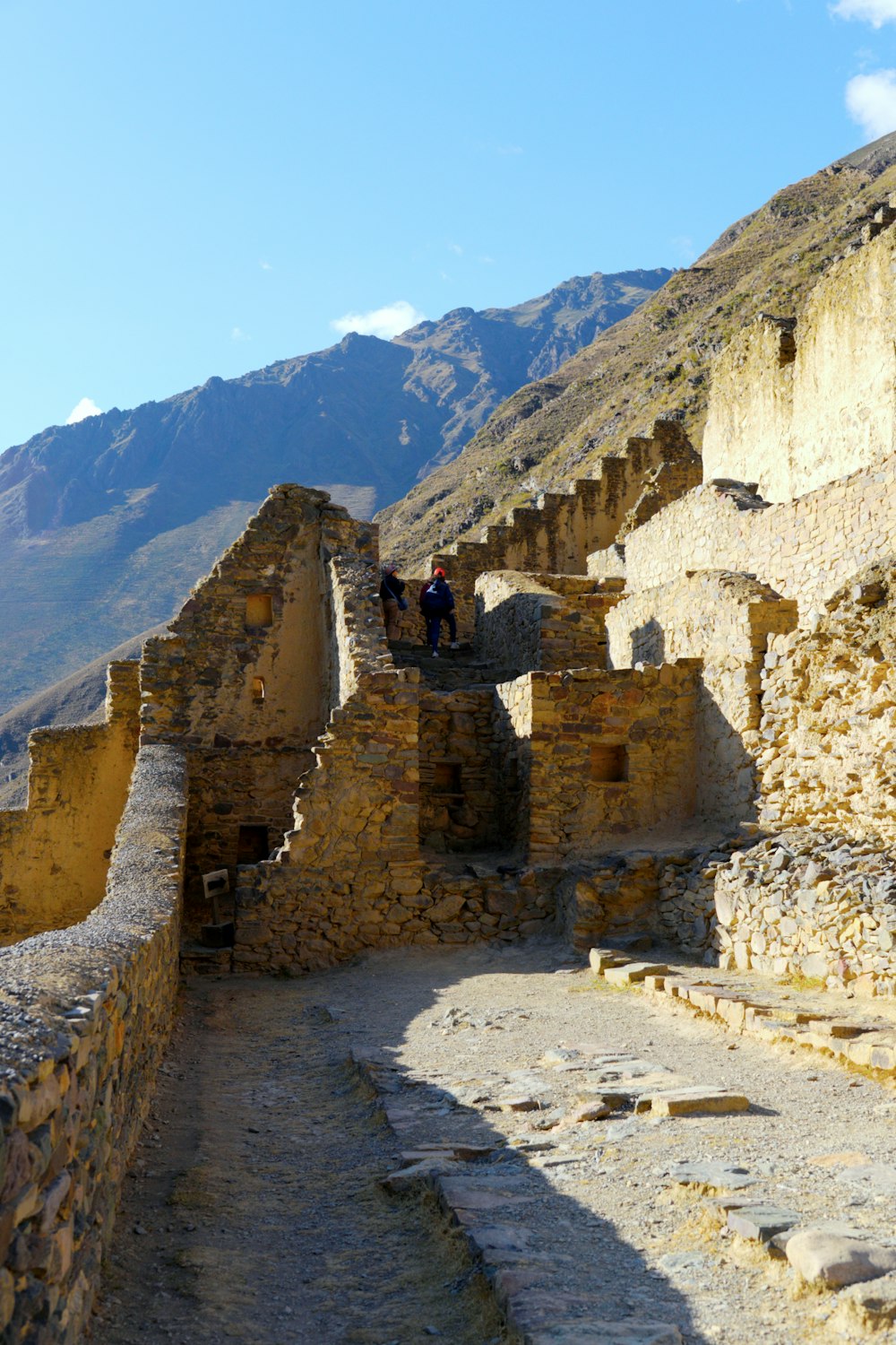 two people are standing on a stone wall