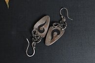 Pair of delicate enamel earrings shaped like kangaroos with intricate Aboriginal dot painting details.
