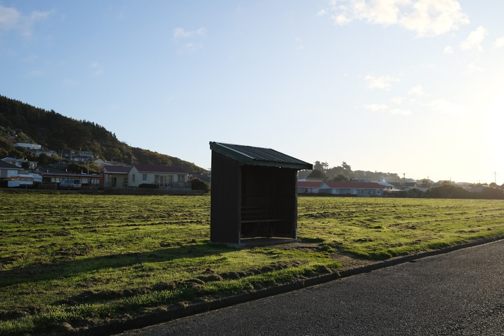 a small outhouse sitting on the side of a road