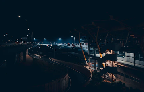 A panoramic view of a sprawling sci-fi airport glowing with lime green holographic interfaces under a dark sky.