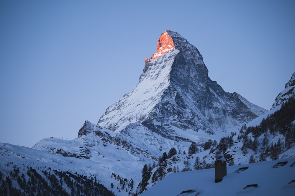 a snow covered mountain with a red light on top of it