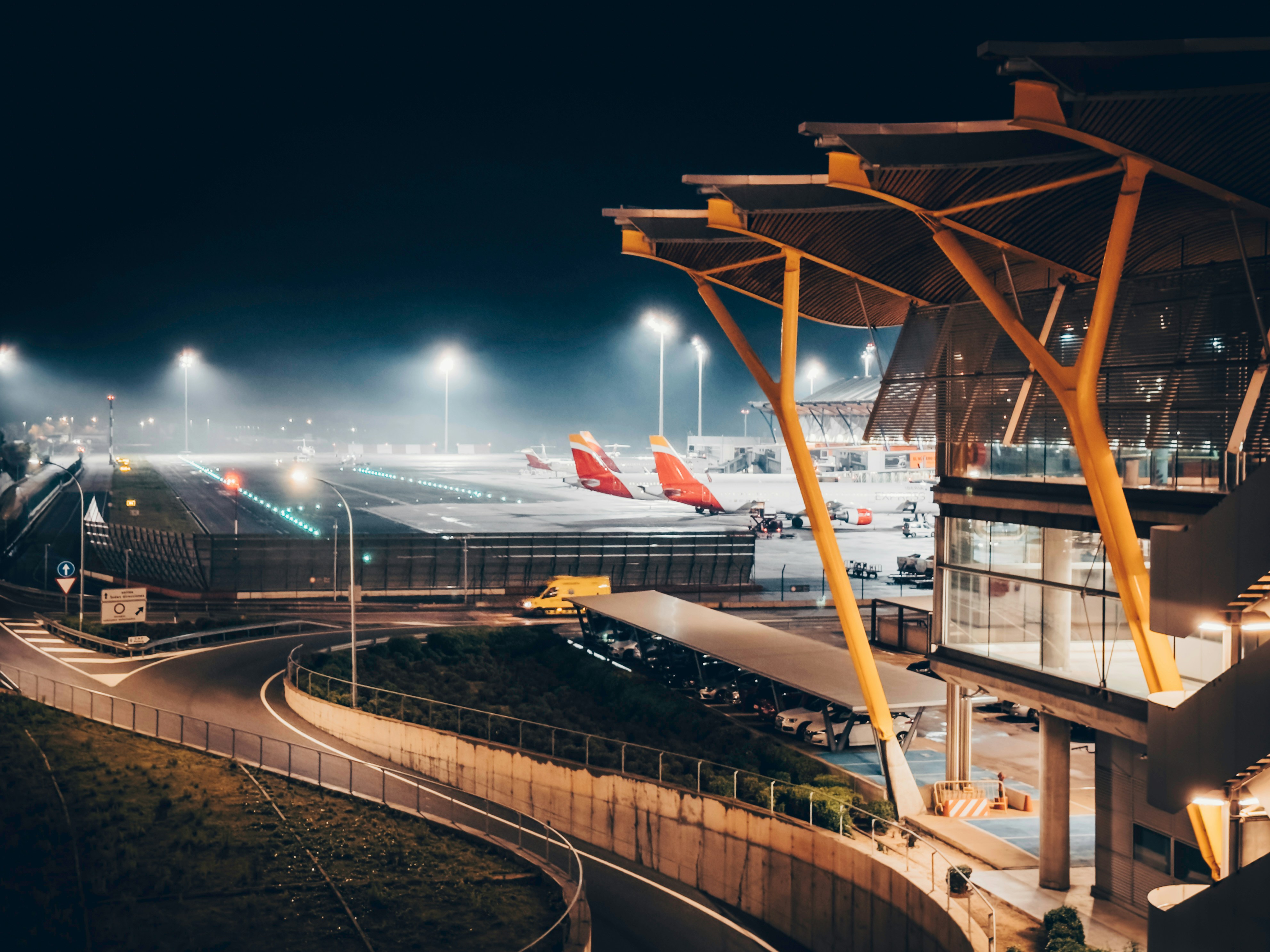 Dark airport tarmac at night with aircraft silhouette, dim runway lights, moody atmospheric scene