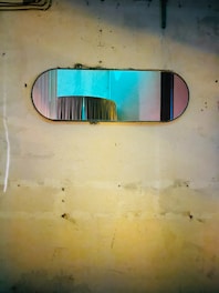 A beautifully framed Moroccan mirror hanging on a textured wall, reflecting soft natural light.