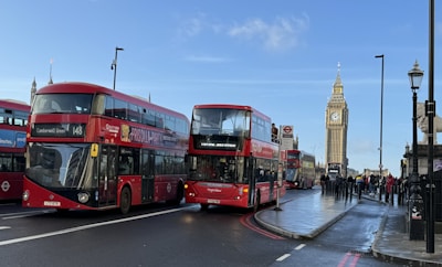 A vibrant street scene in London with red double-decker buses and Big Ben in the background.
