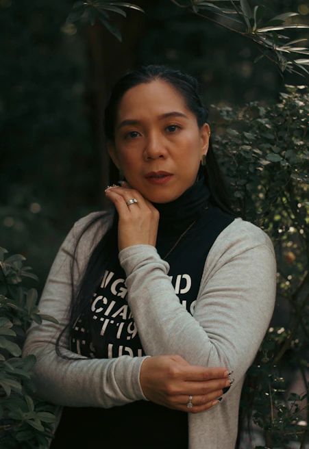 A woman consulting outdoors, surrounded by lush greenery, embodying harmony between business and nature.