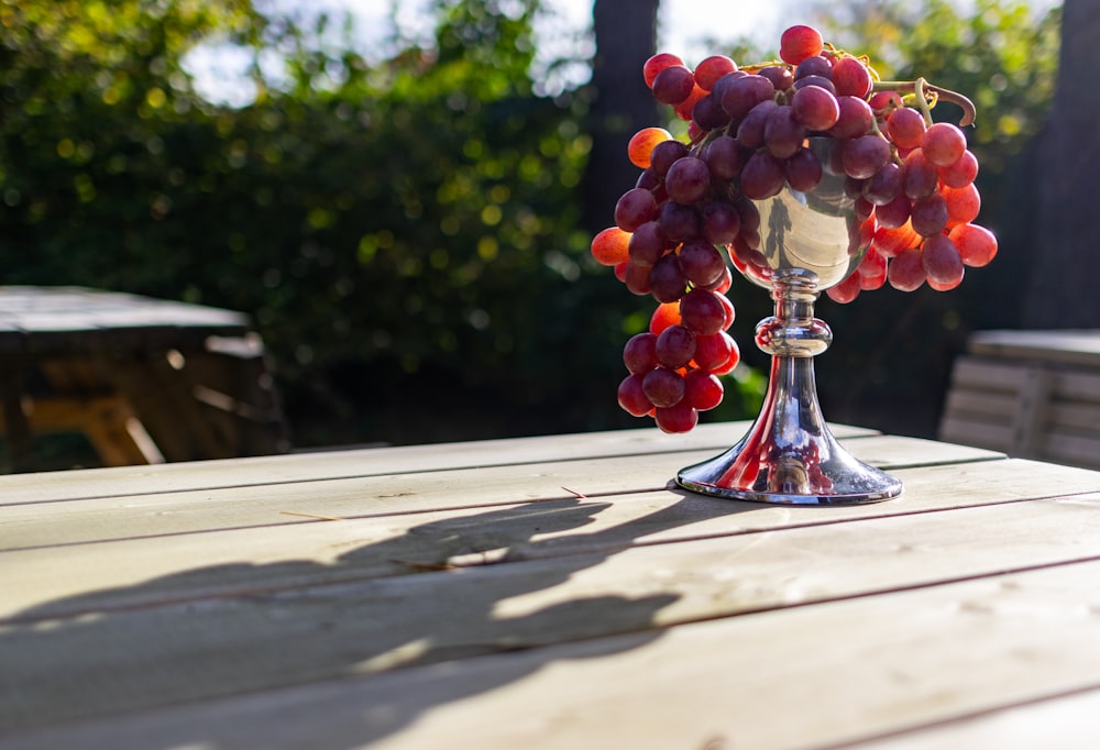 a bunch of grapes sitting on top of a wooden table