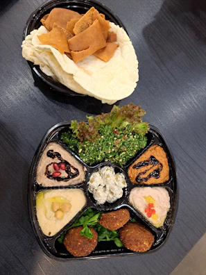 A vibrant platter of assorted mezze including tabbouleh, baba ganoush, and falafel.