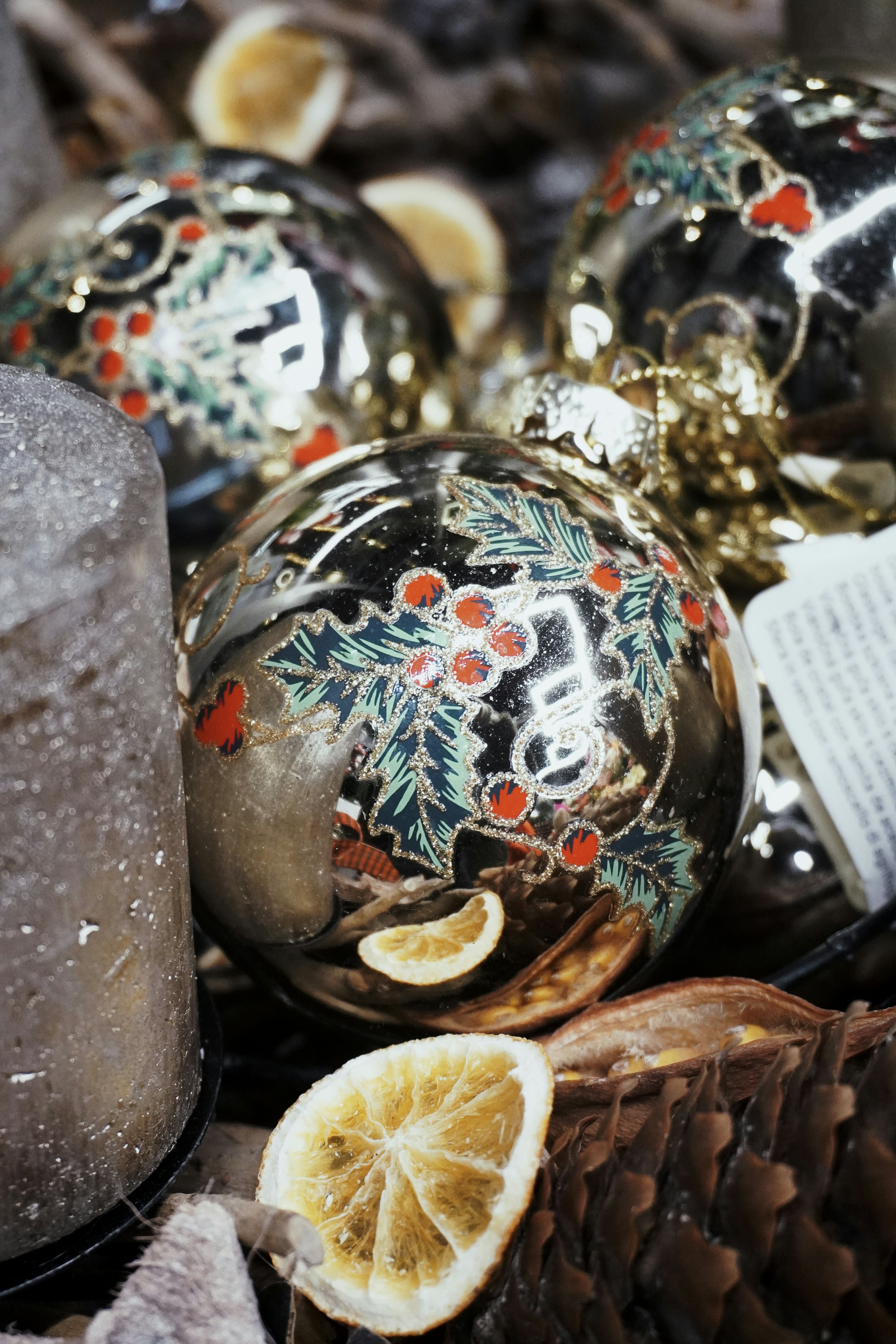 松ぼっくりの山の上に置かれたクリスマスオーナメントの山