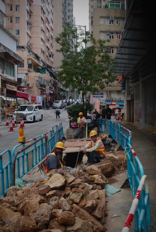 Crew members in full class 3 high-visibility PPE setting up pedestrian ADA-compliant barricades on a busy city street.