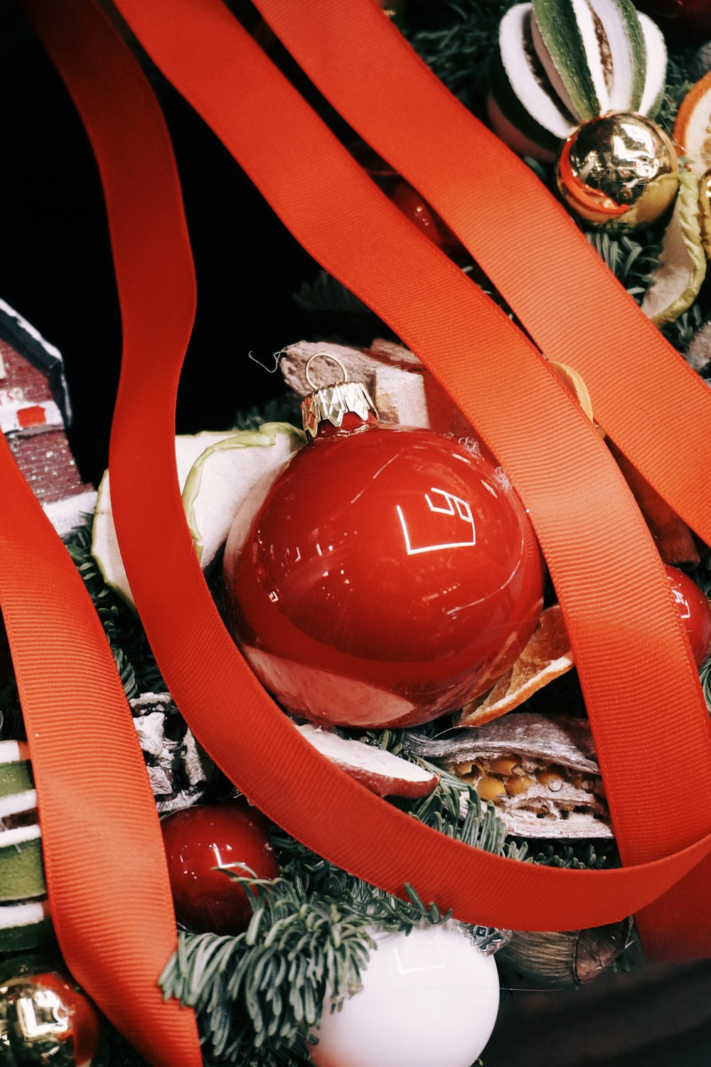 a red christmas ornament with a red ribbon around it