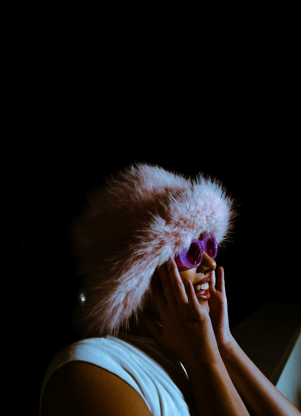 a woman wearing a fur hat and sunglasses