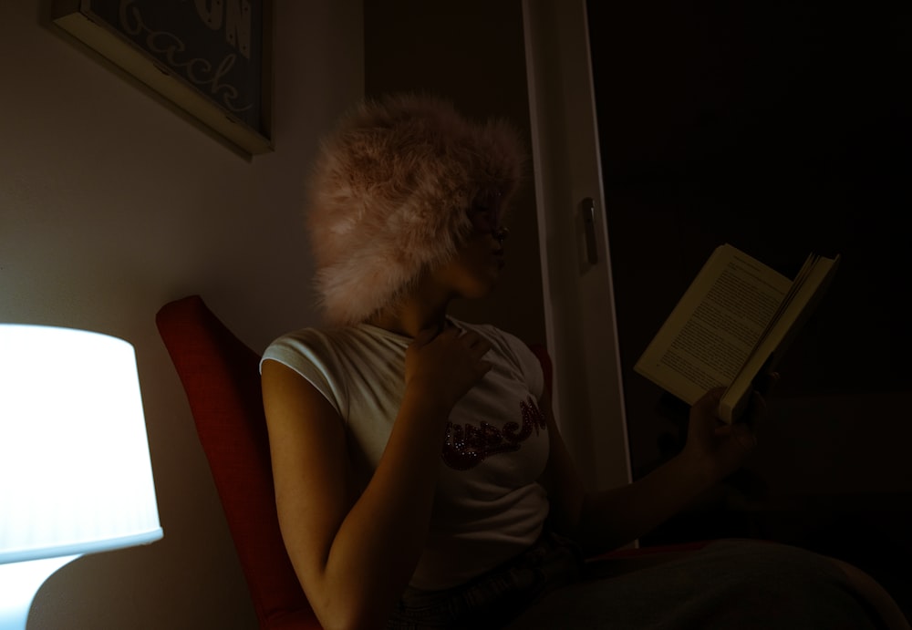 une femme assise sur une chaise lisant un livre