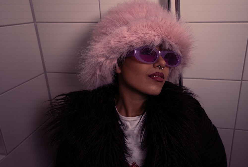 a woman wearing sunglasses and a fur hat