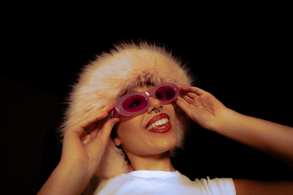 a woman wearing sunglasses and a fur hat